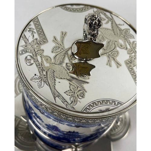 1192 - A Victorian ceramic lidded biscuit barrel in a decorative silver plated stand. Barrel with printed b... 