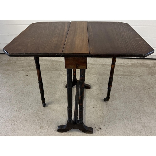 1400 - A small antique dark wood Sutherland style drop leaf table with turned detail to legs. Gateleg suppo... 