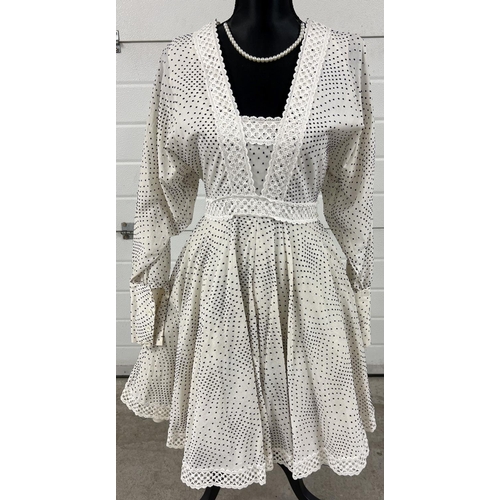A vintage 1960's white cotton polka dot and crochet trim mini dress by Jean Varon - Size 14. Long batwing style sleeves with button cuffs. V neck style front with zip fastening to back. Crochet trim to front yoke and hem of dress, with netted underskirt.