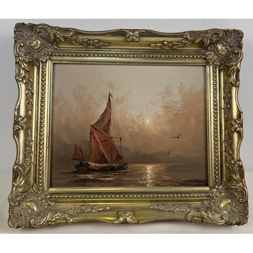 1366 - A small gilt framed oil on board of a sailing boat on peaceful water at sunset. Indistinct signature... 