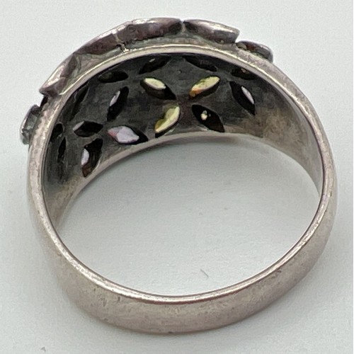 1027 - A modern design dome style silver dress ring with stone set flower detail. Ring set with purple and ... 