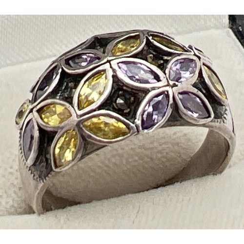 1027 - A modern design dome style silver dress ring with stone set flower detail. Ring set with purple and ... 