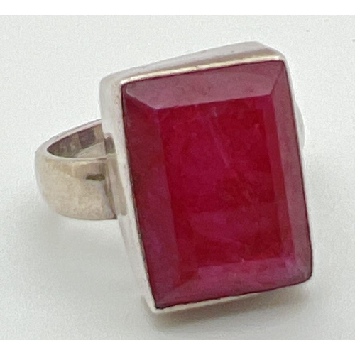 1096 - A modern silver dress ring set with a rectangular cut ruby. Inside of band marked 925. Ring size N. ... 