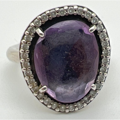 1099 - A 925 silver Glamorous Legacy ring by Pandora. Central purple faceted stone surrounded by small roun... 