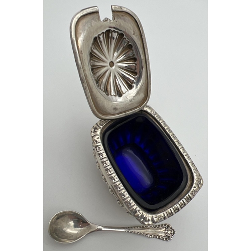 1129 - A Victorian silver mustard pot with blue glass liner and silver spoon. Pot raised on 4 ball feet wit... 