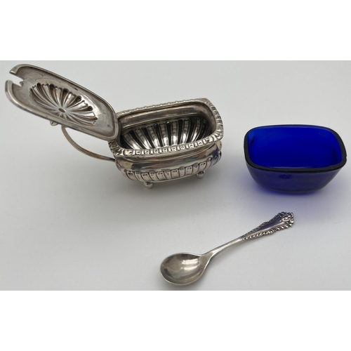 1129 - A Victorian silver mustard pot with blue glass liner and silver spoon. Pot raised on 4 ball feet wit... 