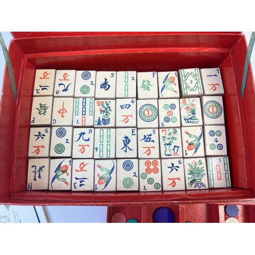 51 - A boxed 1920's Chad Valley Mah-Jong set in original red card box. A complete set of 144 wooden tiles... 