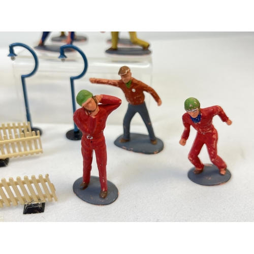 15 - A box of original Tri-ang pit stop figures, fencing, straw bales and other accessories to include 4 ... 