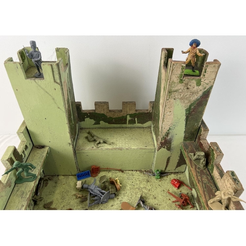 22 - A vintage homemade wooden castle together with a quantity of assorted plastic toy soldiers.