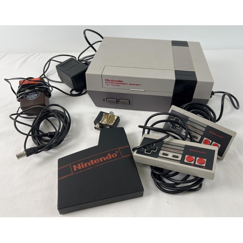 6 - A 1985 Nintendo Entertainment System (NES), with 2 hand held controllers and AC adapter.