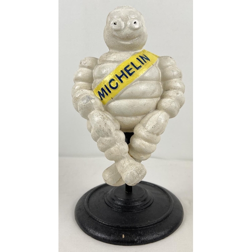 1300 - A painted cast iron figure of a seated Michelin man on a rotating circular pedestal base. Approx. 28... 