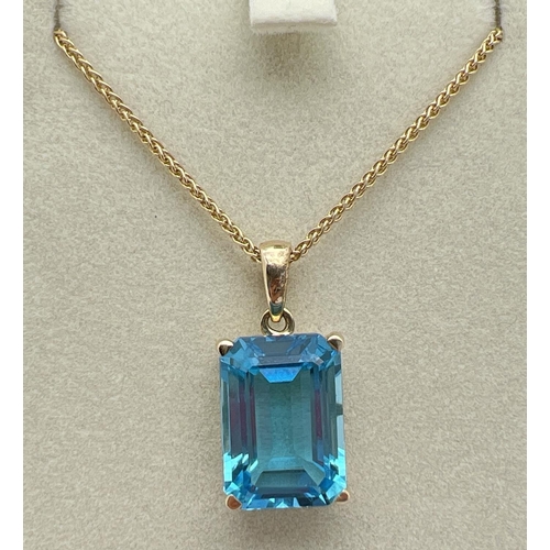 1004 - A modern 9ct gold large emerald cut blue topaz pendant, on an 18