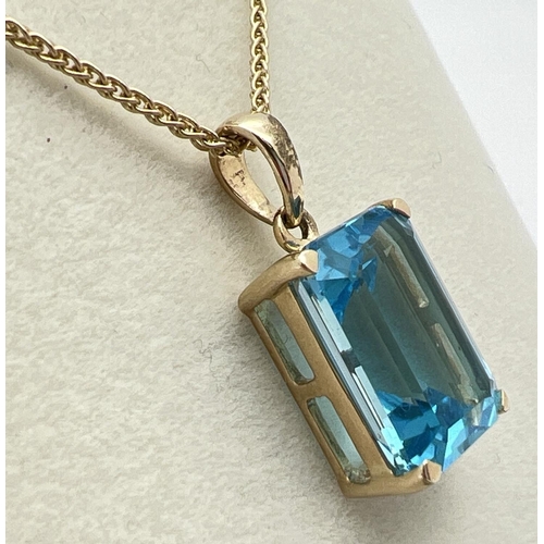 1004 - A modern 9ct gold large emerald cut blue topaz pendant, on an 18