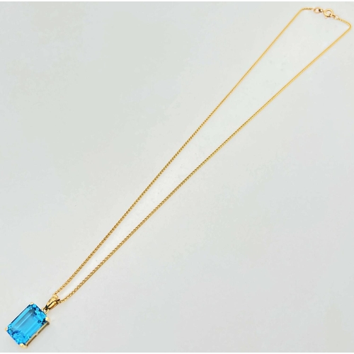 1004 - A modern 9ct gold large emerald cut blue topaz pendant, on an 18