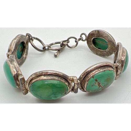 1011 - A six oval panel silver bracelet set with blue/green turquoise, with a t bar clasp. Silver marks to ... 