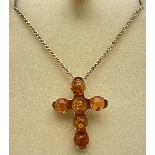 1020 - A boxed 9ct gold amber set cross pendant on an 18