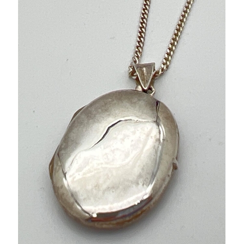 1021 - A plain oval silver locket on an 18