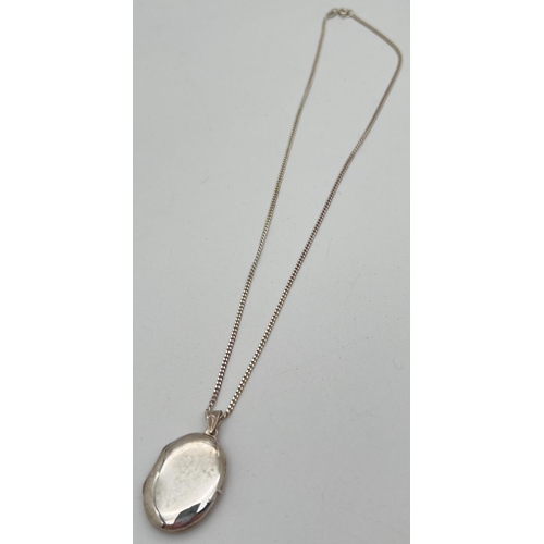 1021 - A plain oval silver locket on an 18