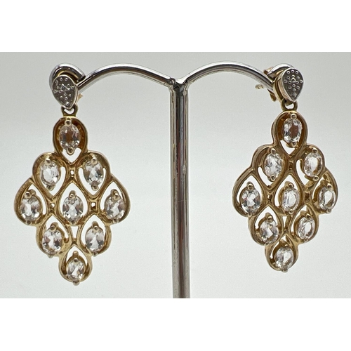 1024 - A pair of silver gilt chandelier style drop earrings each set with 9 clear oval cut stones, by The G... 