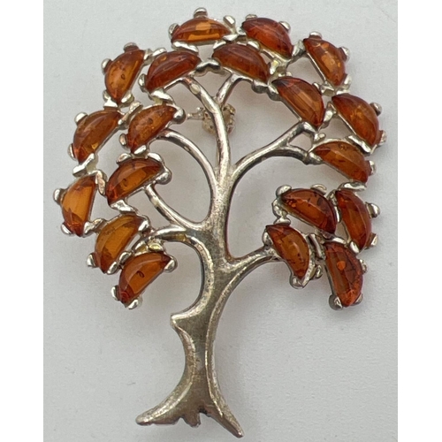 1005 - A 925 silver pendant/brooch in the shape of a tree, set with 19 small pieces of cognac amber.  Hangi... 