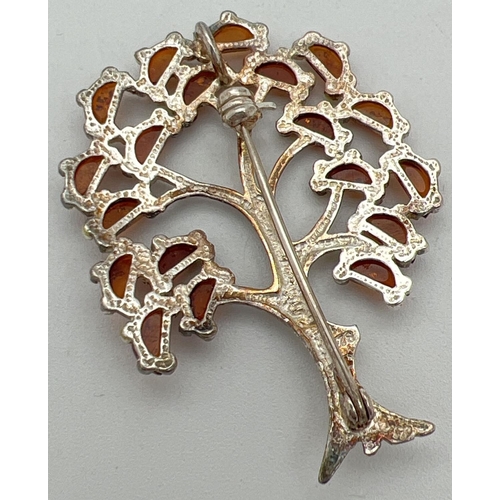 1005 - A 925 silver pendant/brooch in the shape of a tree, set with 19 small pieces of cognac amber.  Hangi... 