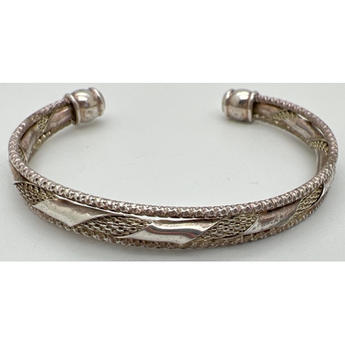 1027 - A decorative 3 band cuff bangle with twist design to middle band. Silver marks to one end. Total wei... 