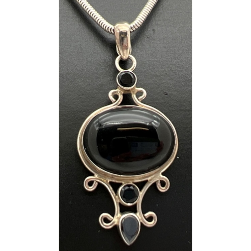 1028 - A decorative modern design silver drop pendant set with black onyx, on an 18