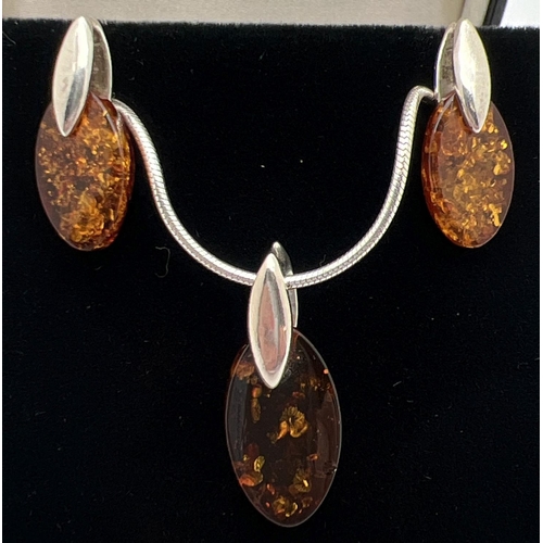 1031 - A modern design silver and amber necklace with matching drop earrings. Marquise cut piece of amber w... 