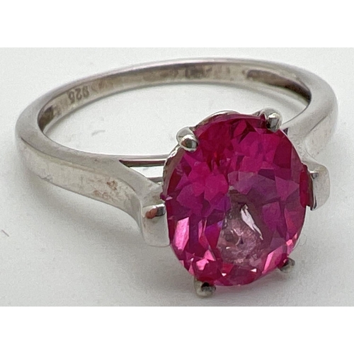 1040 - A 925nsilver and pink topaz solitaire dress ring. Oval cut stone set in a pierced work mount on high... 