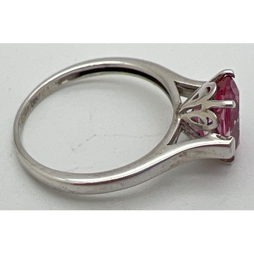 1040 - A 925nsilver and pink topaz solitaire dress ring. Oval cut stone set in a pierced work mount on high... 