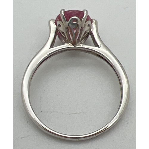 1040 - A 925nsilver and pink topaz solitaire dress ring. Oval cut stone set in a pierced work mount on high... 