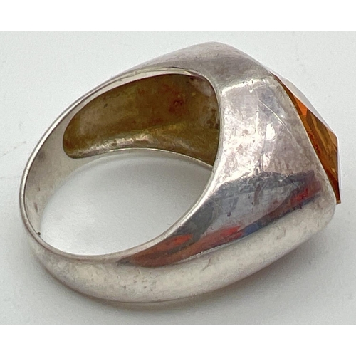 1043 - A modern design silver statement ring set with a pale orange stone. Silver mark to inside of band, S... 