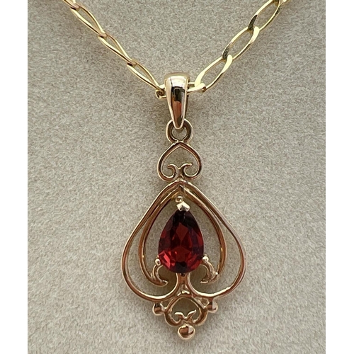 1046 - A boxed 9ct gold Art Nouveau style pendant set with a teardrop cut garnet. On an 18