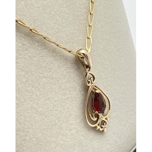 1046 - A boxed 9ct gold Art Nouveau style pendant set with a teardrop cut garnet. On an 18