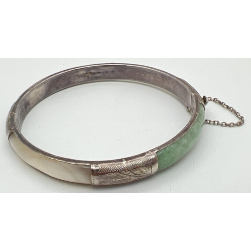 1048 - A silver, mother of pearl and jade panel bangle with push clasp & safety chain. Silver mark to clasp... 