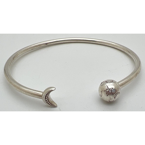 1049 - A silver star and moon stone set bangle by Pandora. Pandora silver marks to inside of bangle and to ... 