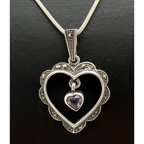 1051 - A silver marcasite set open heart pendant with central heart shaped amethyst drop. On an 18