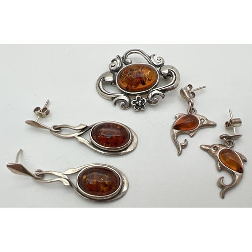 1052 - 3 items of silver and white metal amber set jewellery. An Art Nouveau style brooch with floral mount... 