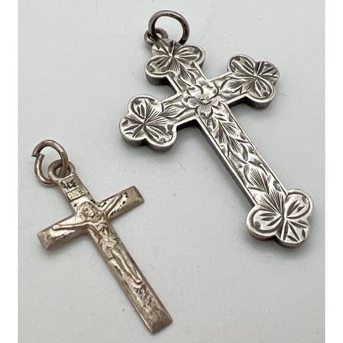 1055 - 2 vintage silver cross pendants. A small crucifix together with a Victorian engraved cross with flor... 