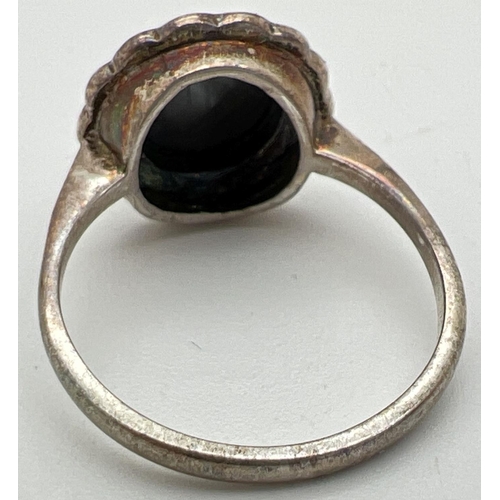 1056 - A vintage silver dress ring set with a central round cut hematite stone, surrounded by 14 marcasite ... 