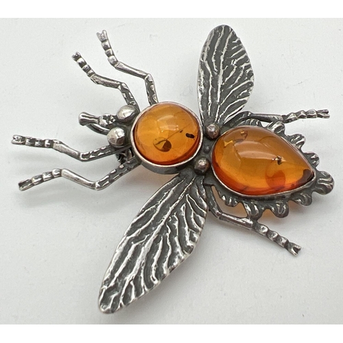 1059 - A white metal amber set brooch/pendant in the shape of a flying insect. Body set with a round and te... 