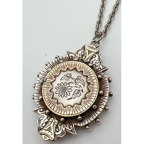 1062 - A Victorian white metal large mourning pendant with gold accents and floral engraving to front. Glas... 