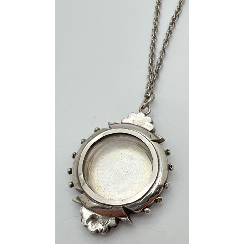 1062 - A Victorian white metal large mourning pendant with gold accents and floral engraving to front. Glas... 