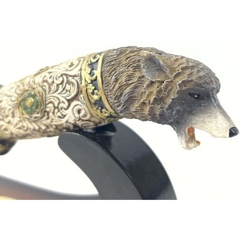 1174 - An ornamental survival style knife with display stand (a/f). Resin handle in the shape of a wolfs he... 