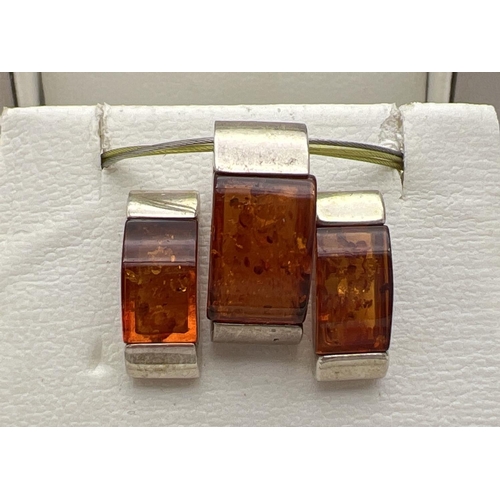 1073 - A boxed silver & amber modern design necklace & matching earrings set with cognac amber. Pendant on ... 