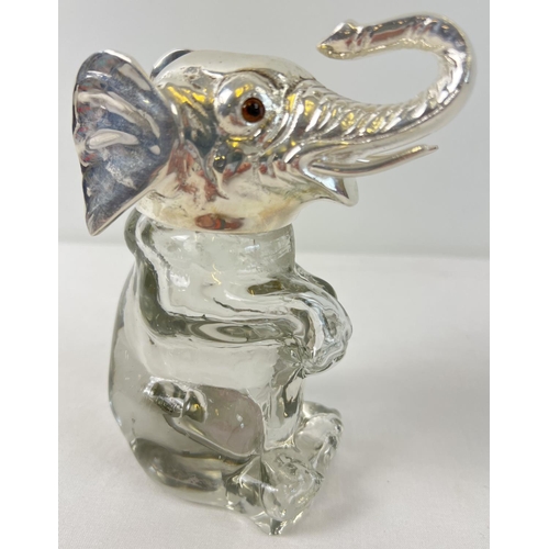 1110 - A clear glass bottle/decanter modelled as an elephant with a silver plated lid and rim. With brown g... 