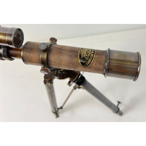 1315 - A brown leather bound brass desktop telescope on a folding tripod stand. Approx. 30cm tall.