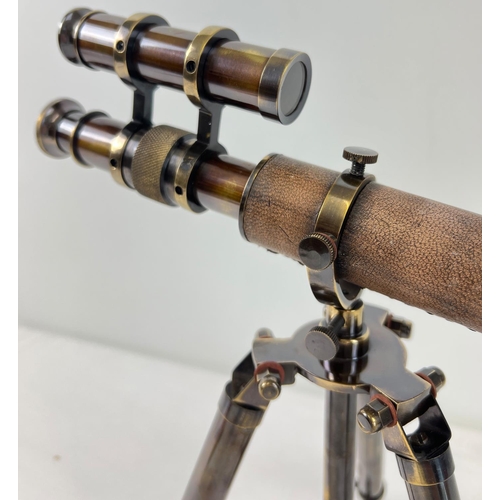 1315 - A brown leather bound brass desktop telescope on a folding tripod stand. Approx. 30cm tall.