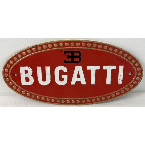 1293 - An oval shaped Bugatti cast iron wall plaque, painted red, black, white & gold. Approx. 17cm x 35cm.