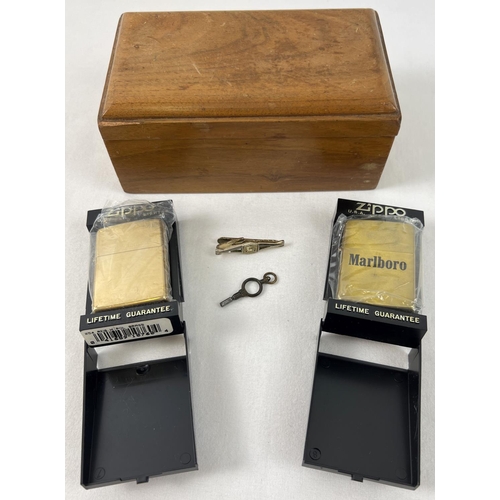 1325 - 2 cased Zippo Lighters together with a small wooden box, watch key & car detail tie clip. A plain so... 